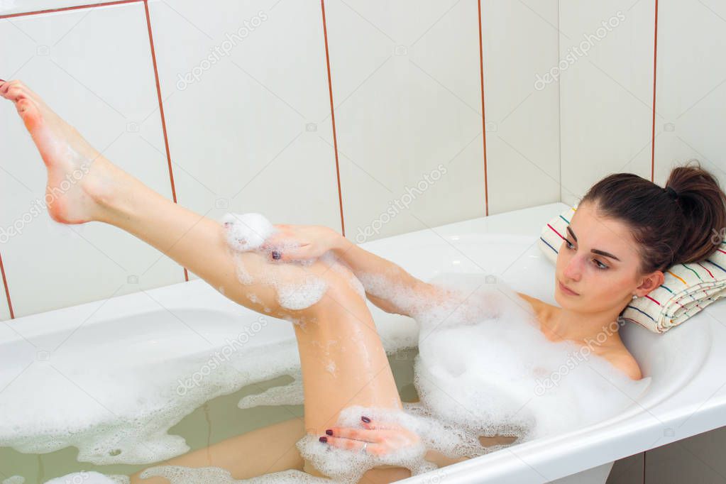 girl is bathed in a tub with foam