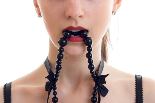 Portrait d'une jolie fille avec rouge à lèvres rouges sur les lèvres qui garde dents perles noires gros plan — Photo