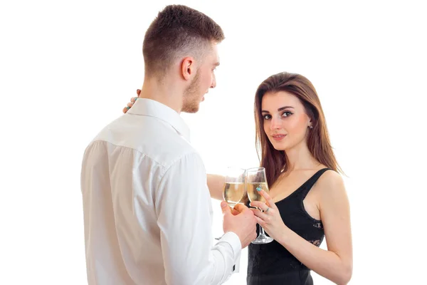 Attractive young girl standing next to a guy and holding wine glasses with him — Stock Photo, Image