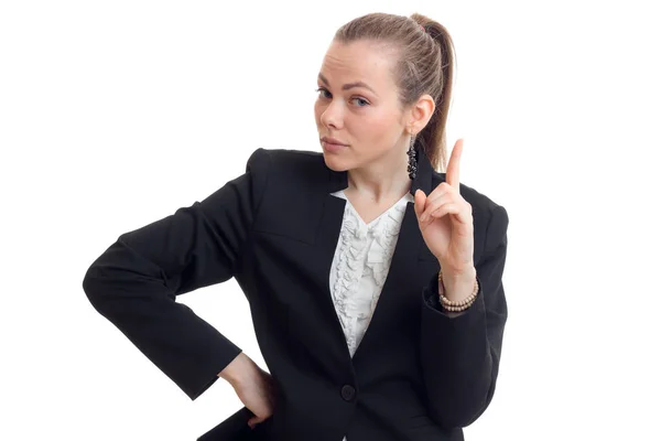 Jovem mulher de negócios bonita em casaco preto mantém a mão na lateral mostra o gesto e olha para uma câmera — Fotografia de Stock