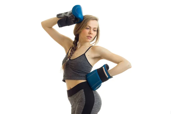 Een atletische meisje in grijs pak en bokshandschoenen poseren op camera — Stockfoto