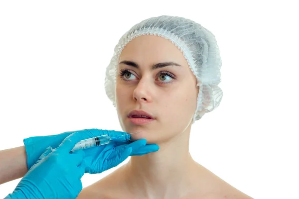 Seorang gadis muda bertopi yang melakukan injeksi wajah medis terisolasi pada latar belakang putih — Stok Foto