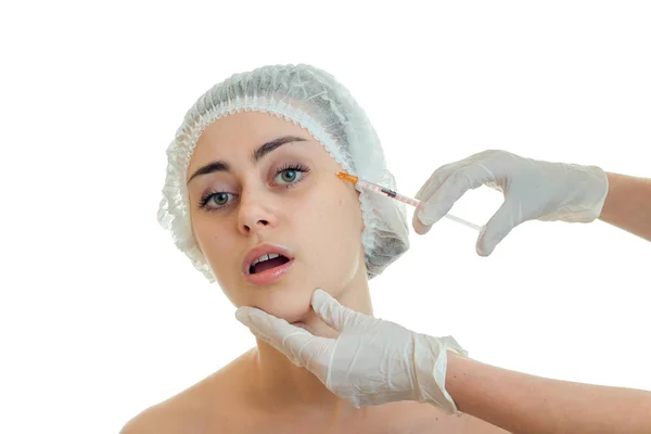 Una chica joven con un sombrero médico con la boca abierta que el médico en su cara hace meter en guantes blancos de cerca —  Fotos de Stock