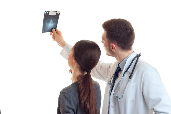 Una joven y un médico de pie con ella, de vuelta a la cámara y mirando rayos X —  Fotos de Stock