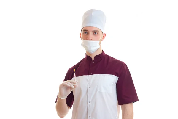 Giovane medico di laboratorio con cappello e maschera sul viso con una siringa — Foto Stock