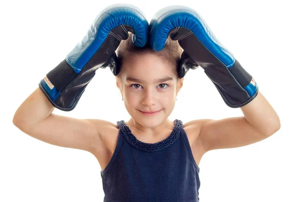 Niña sosteniendo las manos sobre la cabeza con un gran primer plano guantes de boxeo —  Fotos de Stock