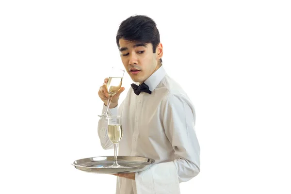 Encantador camarero con una camisa blanca sosteniendo una copa de vino y maravillas —  Fotos de Stock