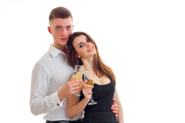 Young guy standing next to a beautiful girl smiling and holding wine glasses — Stock Photo, Image