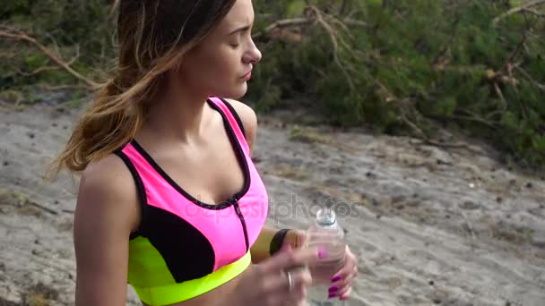 Mooi meisje water drinkt na buiten training — Stockvideo