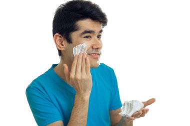 genç çekici adam yana gülümsüyor standları ve köpük yüzüne neden olur