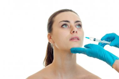 Doktor mavi eldiven beyaz bir arka plan üzerinde izole kız yüzünde bir analjezik şırınga enjeksiyon yapıyor