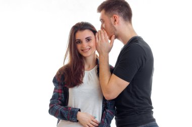 genç adam kıza onun kulağına bir şey söylüyor ve gülümsüyor