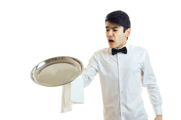 Der junge Kellner mit offenem Mund lässt ein Tablett mit Geschirr fallen — Stockfoto
