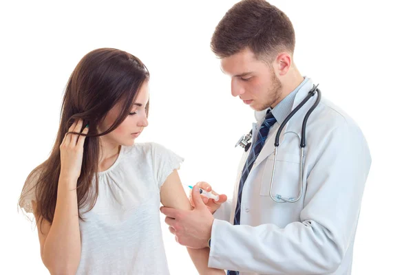 Un médico joven con una bata de laboratorio blanca hace pinchazo chica de cerca —  Fotos de Stock