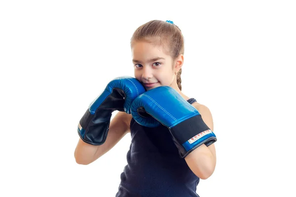 Little girl smiling and holding hands in a large adult boxing gloves near individuals — Stock Photo, Image