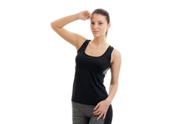 Snella ragazza atletica in t-shirt nera e posa sulla macchina fotografica — Foto Stock