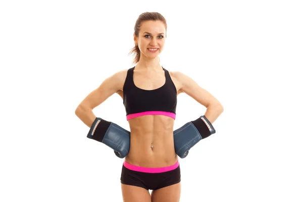 Cute young girl at the top with press on her stomach stands in boxing gloves — Stock Photo, Image