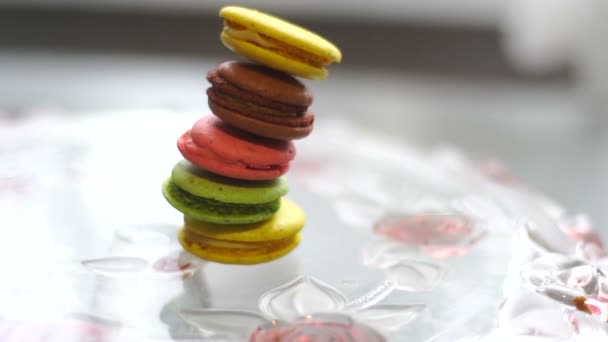 Multi-gekleurde macaroon cookies valt op de plaat — Stockvideo