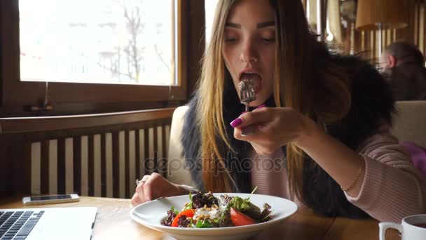 Beautiful young girl eats tasty salad — Stock Video