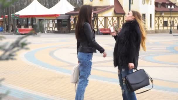 Две девушки подруги разговаривают на улице — стоковое видео