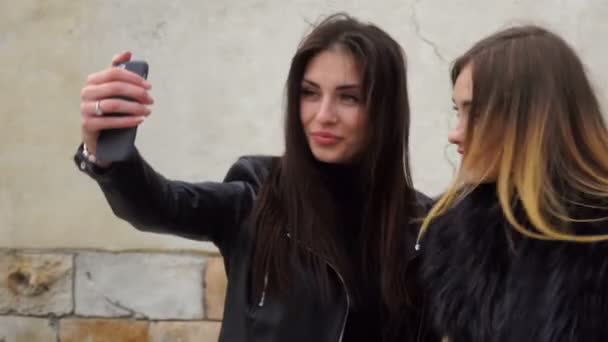 两个漂亮的女孩在电话上使自拍照 — 图库视频影像