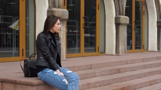 Chica joven glamorosa sonriendo a la cámara en la calle — Vídeo de stock