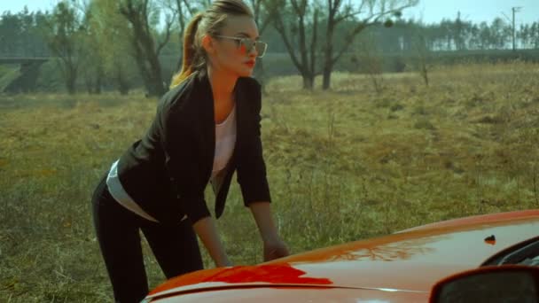 Sexig tjej öppnar huven på bilen — Stockvideo