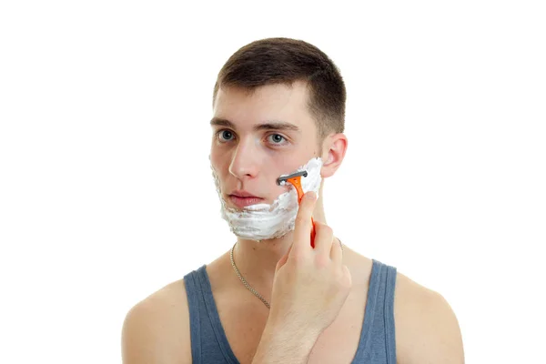 Cara olha para a distância e barba sua barba com uma espuma — Fotografia de Stock