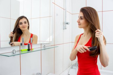 genç kız güzel saçlarını bir ayna önünde penye kırmızı yelek