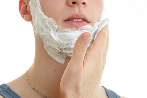 Портрет человека, который наносит пену для бритья на бороду крупным планом — стоковое фото