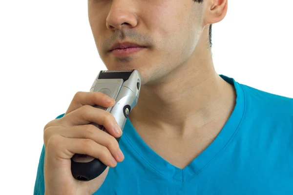 Het gezicht van de jonge man die zijn baard trimmer close-up scheert — Stockfoto