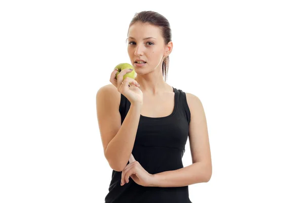 Linda joven sin maquillaje sostiene en su mano una manzana verde y se ve de cerca — Foto de Stock