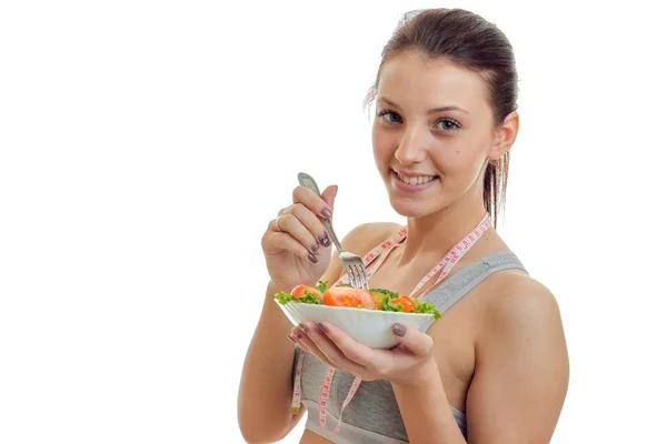 Giovane bella ragazza sorridente che tiene vicino al piatto faccia di un primo piano insalata di verdure — Foto Stock