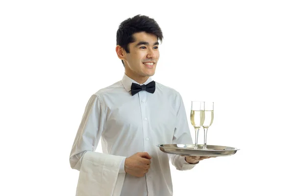 Uśmiechający się przystojny kelner z czarnymi włosami i koszula taca z dwóch kieliszków wina — Zdjęcie stockowe