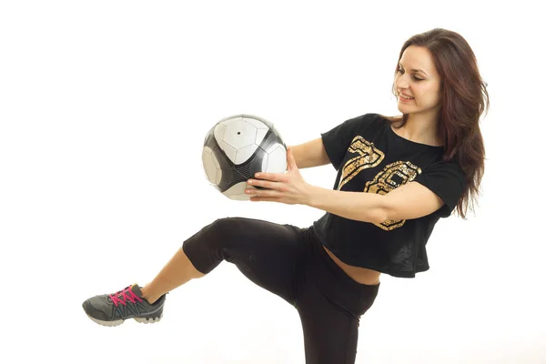 Young cheerful sportswoman in black kicks a soccer ball kicked — Stock Photo, Image