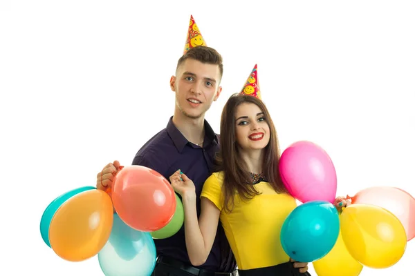 Alegre belo casal celebrando aniversário rindo e segurando muitas bolas — Fotografia de Stock