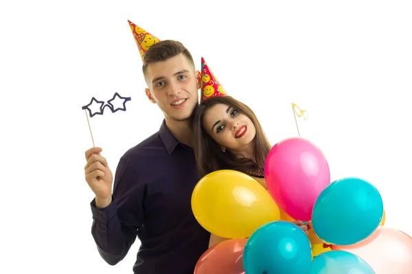 Maravilloso joven con una chica mirando a la cámara sonriendo y llevando globos y transferencia de papel — Foto de Stock