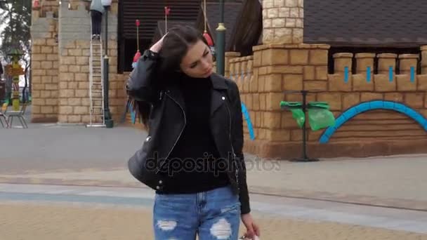 Charmiga brunett promenader i gatan och ler in i kameran — Stockvideo