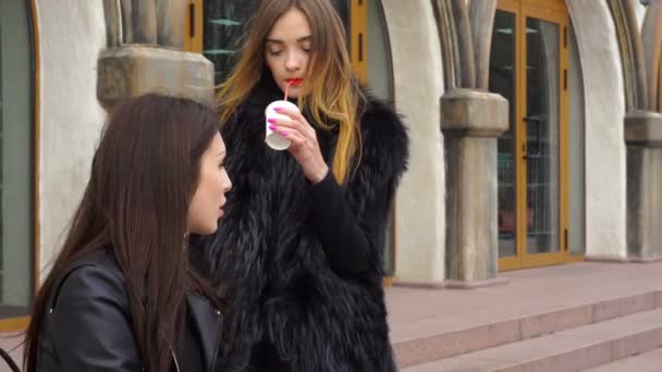 Dwie śliczne dziewczyny rozmowy i picia kawy na ulicy — Wideo stockowe