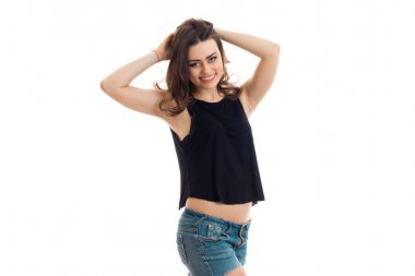 çekici bir genç hanım bir siyah t-shirt ve kot şort gülümsüyor ve eller saç tutar