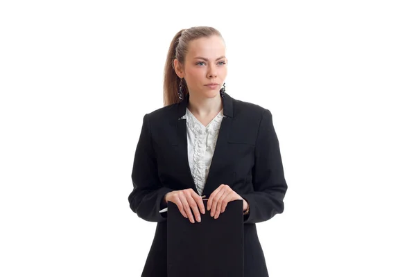 Молодая очаровательная девушка в черной куртке выглядит прямо и держит планшет — стоковое фото