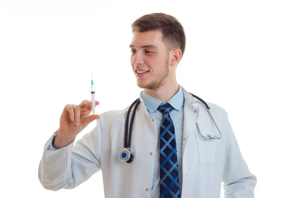 Красивий молодий лікар посміхається і тримає вакцину для шприца крупним планом — стокове фото
