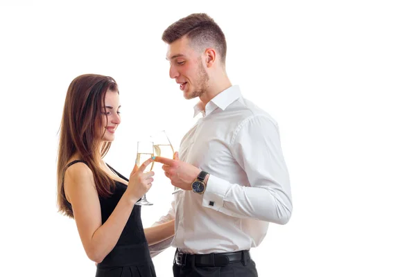 Beautiful tall guy in a white shirt standing next to an attractive girl, and they drink champagne from glasses — Stock Photo, Image