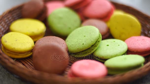 Chica pone las galletas de macarrón francés en un tazón — Vídeos de Stock