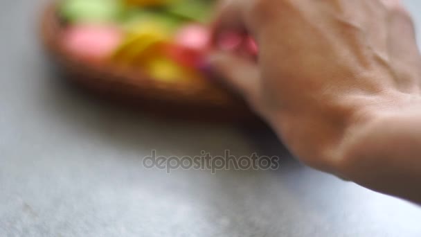 Девушка берет плетеную тарелку с печеньем из макарон — стоковое видео