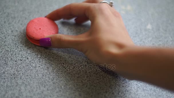 Flicka sätter rosa kakor på bordet i en rad — Stockvideo