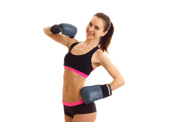 A cheerful athletic girl stands in boxing gloves and short shorts in front of the camera and smiling — Stock Photo, Image