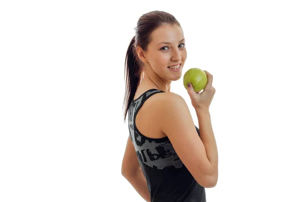 快乐年轻的体操运动员看台侧身和持有绿色苹果特写 — 图库照片