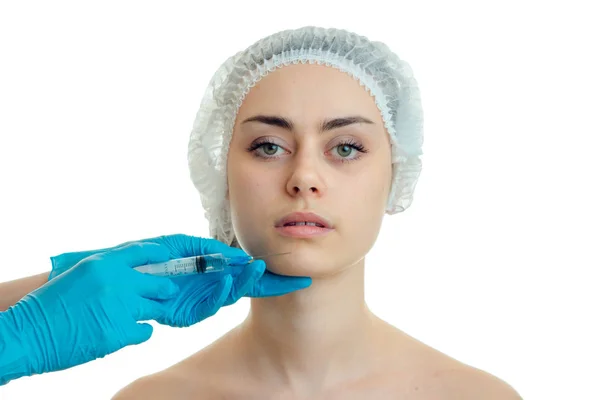 Portrait of a beautiful young girl who looks directly into medical and physician hair Hat gloves touches her face — Stock Photo, Image