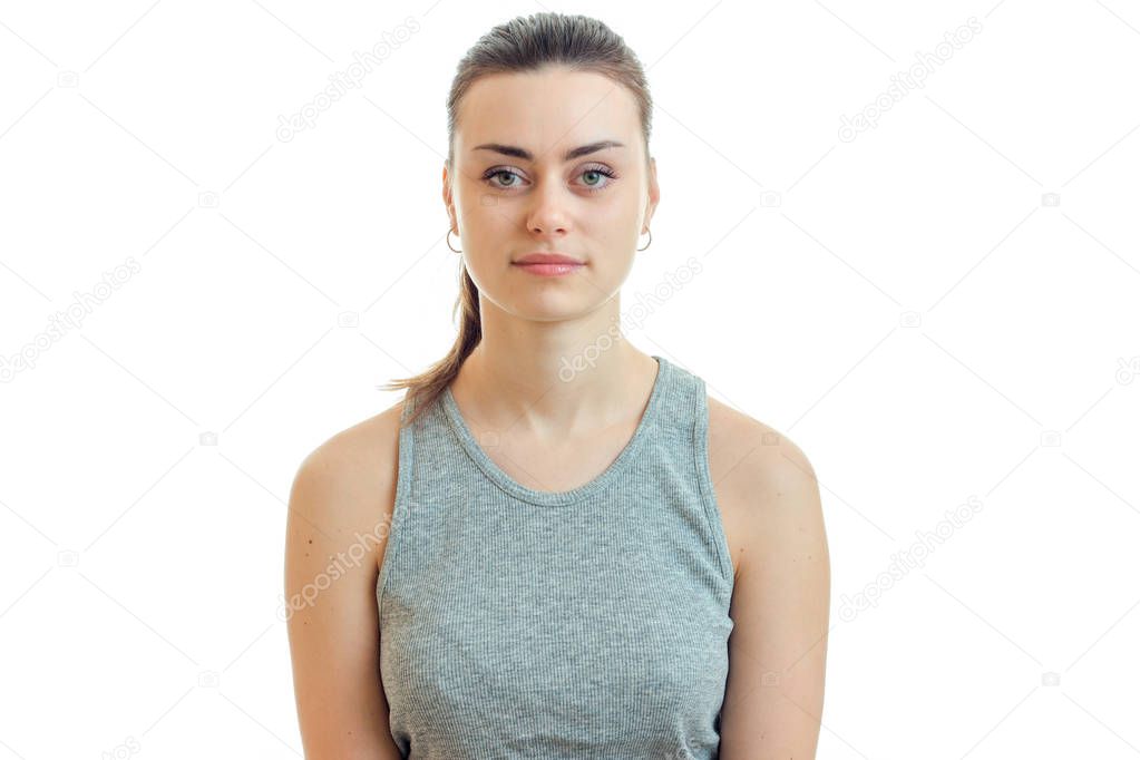 Portrait of a beautiful woman in a gray t-shirt and with the collected hair that stands straight up and seriously looking at camera